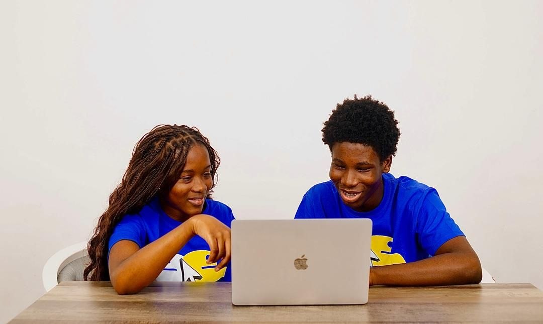 CJpy Cohort students working together at a laptop